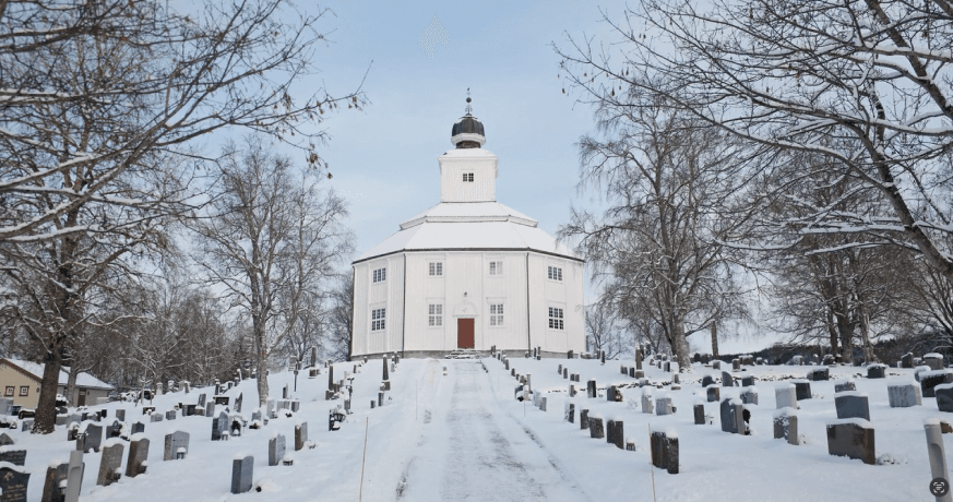 bilde av en hvit kirke i vinterkledd landskap